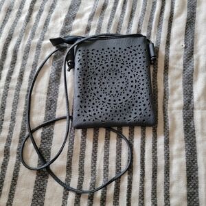 Unbranded crossbody with Lazer etched detail on front.